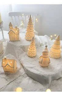 Glow-in-the-dark white ceramic Christmas tree and house tabletop decor with warm lights