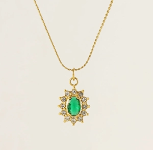 Close-up of golden sunflower pendant with green oval stone and white zircon accents
