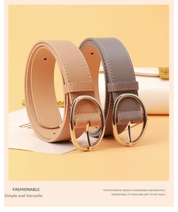 Close-up of beige and grey leather belts with elegant golden oval pin buckles