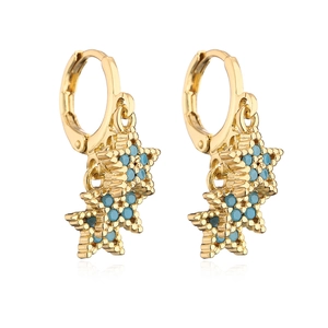 Detail of 18K gold plated star earrings with blue zircon inlays on white background