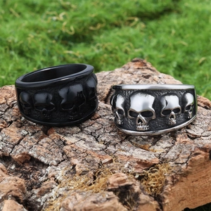 Detailed relief of punk skull rings in black and antique silver on rustic bark background