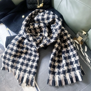 Detailed view of heavy houndstooth scarf texture with fringe on elegant still life