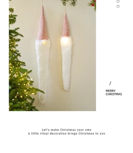 Detail of LED glowing white beard Santa ornament on warm festive Christmas tree background