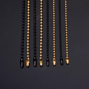 Polished titanium steel ball bead chains in gold and black displayed on reflective surface