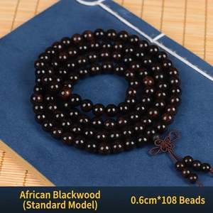 Macro detail of 108 ebony wood prayer beads with traditional Chinese knot tassel
