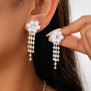 Detailed view of elegant silver flower earrings with white pearls and diamond tassels