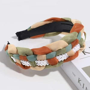 Detail of woven mesh headband with white pearls on a minimalist book background