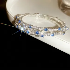 Three-layer silver bangle with sparkling white zircons and blue rectangular gemstones