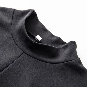 Detail of the high neckline and stitching on this slim black textured dress
