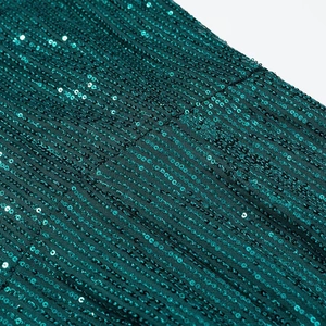 Close-up of deep green sequins on mesh fabric showing texture and shimmering effect