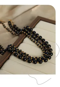 Close-up of black onyx beaded necklace with gold spacers and vintage OT toggle clasp detail
