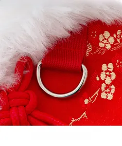 Detail of red pet vest with gold floral embroidery, faux fur trim, and metal D-ring