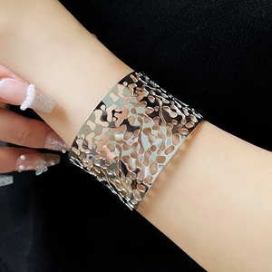 Macro shot of silver irregular cutout cuff bracelet showing organic hollowed texture