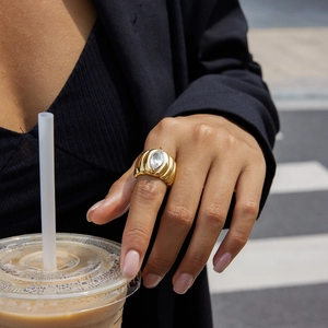 Détail d'une bague en acier doré 18K avec pierre marquise blanche sur un mannequin