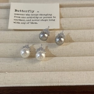 Macro detail of natural freshwater pearl stud earrings with micro-inlaid diamond crowns