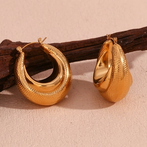Detail showing 18K gold plated lava textured teardrop earrings on a wooden stand