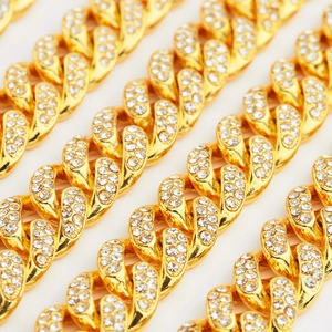 Macro view of gold plated Cuban link chain with detailed sparkling pavé rhinestones