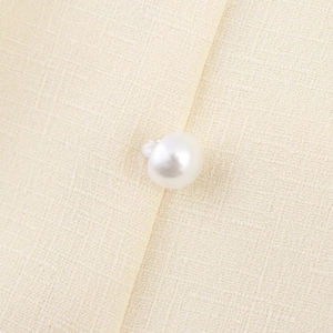 Elegant beige textured shirt featuring lantern sleeves and delicate pearl button detail