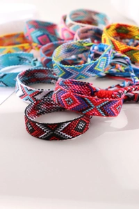 Macro shot showing colorful hand-woven Bohemian friendship bracelets with ethnic patterns