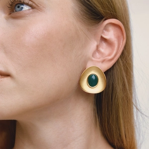Close-up of vintage matte gold oval earrings with deep green oval resin stone inlay