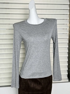 Detail of grey slim fit long-sleeve wool T-shirt fabric texture on a mannequin