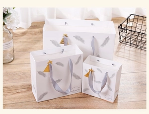 Three-piece set of white Christmas gift bags with gold trees and grey silk handles