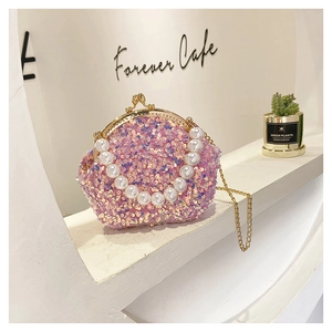 Pink sequin shell bag with golden metal frame and luxury pearl bead handle detail