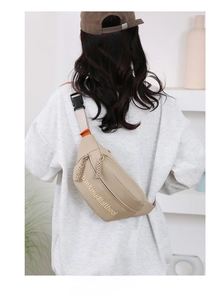 Detail of casual canvas crossbody bag on a model showing sizing and adjustable strap