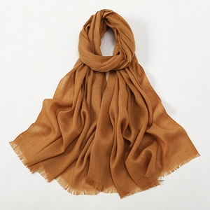 Detailed texture of brown slub cotton scarf with fine fringe edges on white background