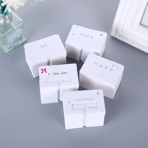 White cardboard hair accessory display cards with T-shaped slots and minimalist patterns