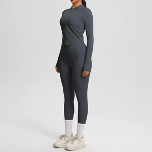 Détail d'un ensemble de yoga gris foncé avec veste zippée et legging à poche latérale