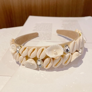 Detailed view of beige baroque headband with seashells, pearls and rhinestones decoration