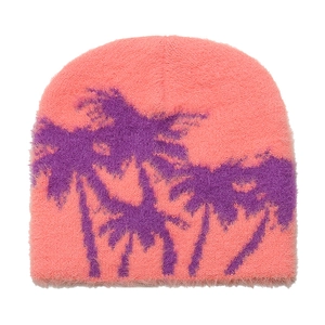 Detail of pink knitted beanie featuring fuzzy texture and purple palm tree jacquard pattern