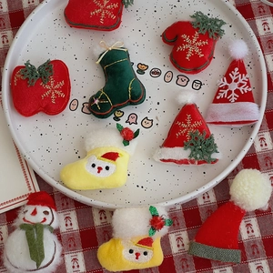 Close-up of handmade felt Christmas ornaments including snowman and socks on a tray