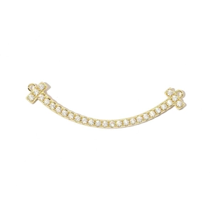 Detalle de un colgante de sonrisa curva bañado en oro de 18k con circonitas brillantes