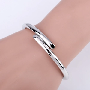 Detail shot of minimalist silver cuff bracelet with polished finish and smooth round edges
