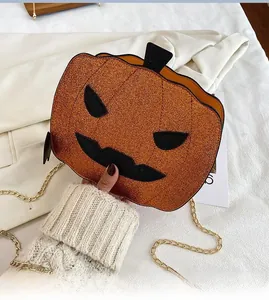 Close-up of glittery orange pumpkin bag with gold chain and black facial patches