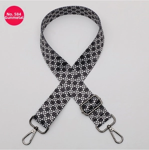 Detail of adjustable polyester strap with black white floral pattern and gunmetal hooks