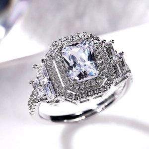 Anello di lusso con zircone taglio radiant, doppio halo e pietre laterali a trapezio