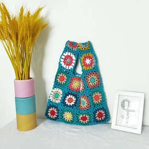 Detail of handmade crochet tote bag featuring vibrant blue floral granny squares