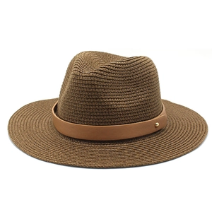 Détail d'un chapeau fedora en paille marron avec tissage dense et ruban en cuir chic