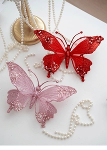 Macro detail of Christmas butterfly ornament with red mesh glitter and faux pearl beads
