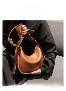 Vue détaillée d'un sac besace marron en similicuir avec zip doré et bandoulière