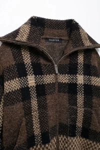 Detail view of plaid knit bomber jacket featuring silver zipper and fuzzy texture