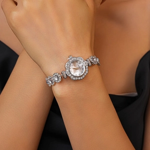 Close-up of silver flower-shaped quartz watch with crystal inlay on woman's wrist