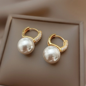 Elegant 925 silver pearl earrings with gold plating and zircon inlay on a jewelry box