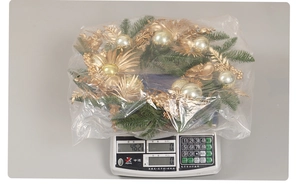 Detail of a festive Christmas wreath with golden ornaments and green pine needles