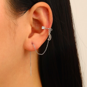 Detail of silver ear cuff chain with crescent moon pendant and zircon stud earring