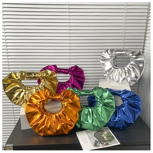 Makroaufnahme von metallischen Faltenhandtaschen in Gold, Silber und bunten Farben