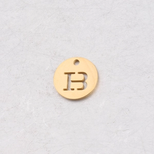 Détail d'un pendentif rond de 12mm en acier doré avec la lettre B découpée au centre